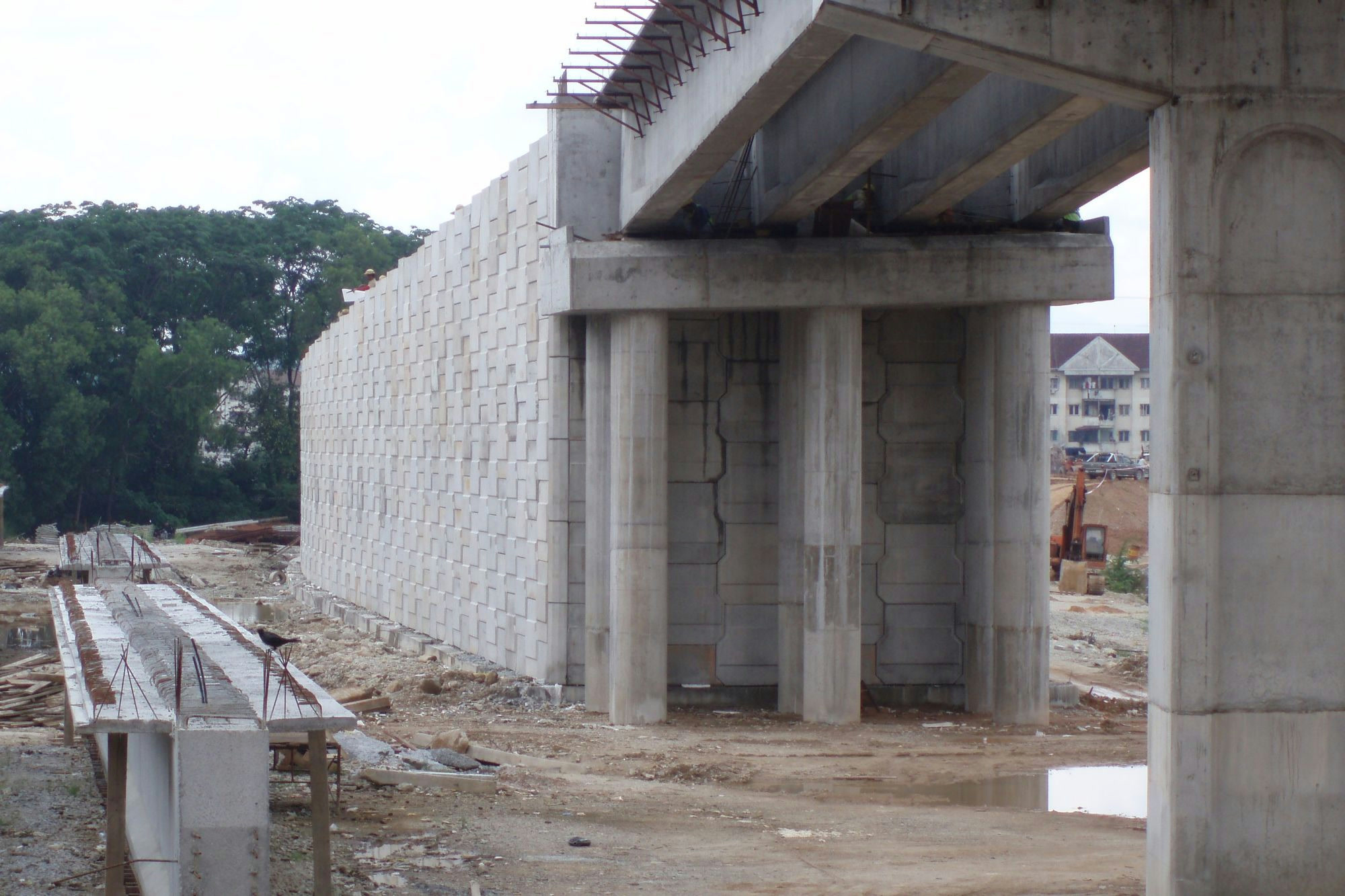 AnchorSOL bridge abutment wall meeting bridge deck, inverted-T precast facing visible alongside the bearing piers